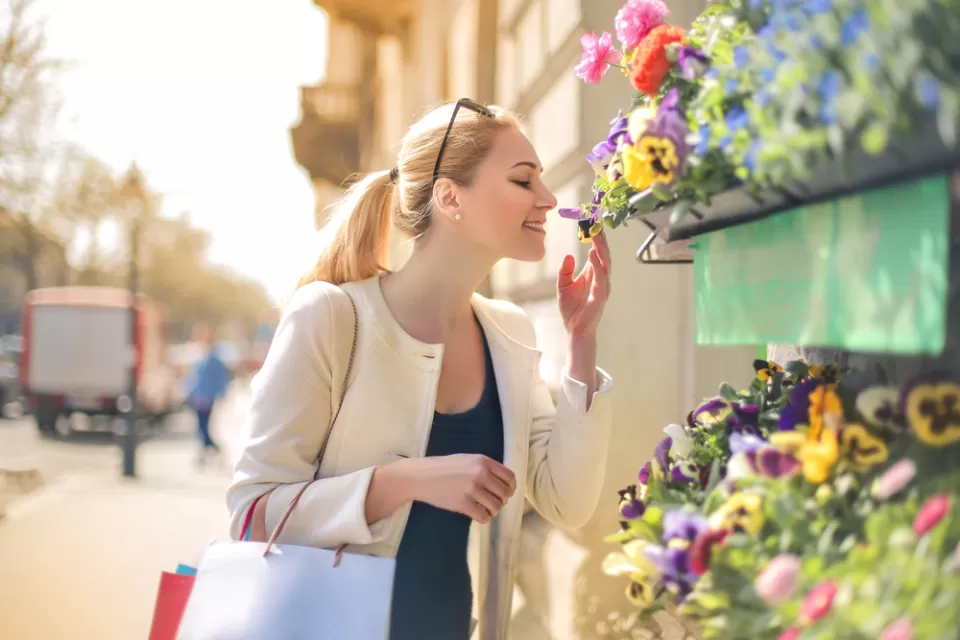 Woman smelling flowers at a street stand